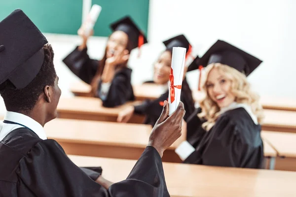 Mnohonárodnostní studenti neukazují diplomy — Stock fotografie