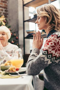 Kıdemli anne ve kızı Noel'de dua