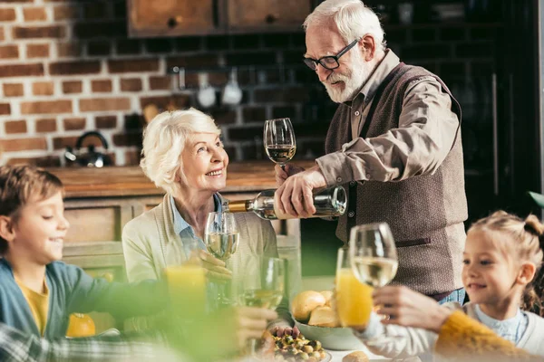 Seniorchef schenkt Frau Wein ein — Stockfoto