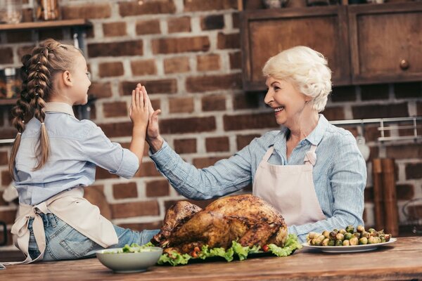grandmother and granddaughter giving high five