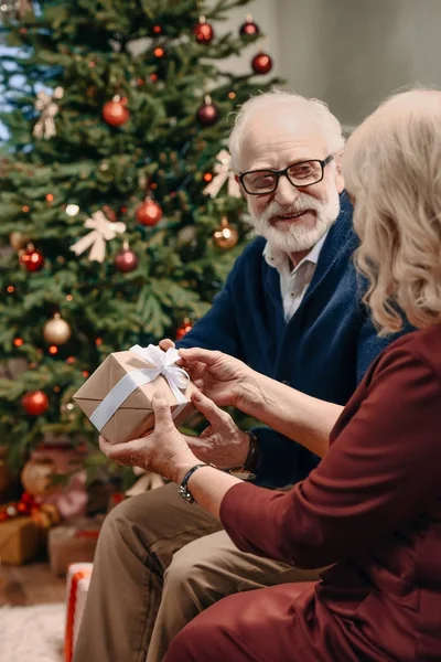 man presenting christmas gift to wife