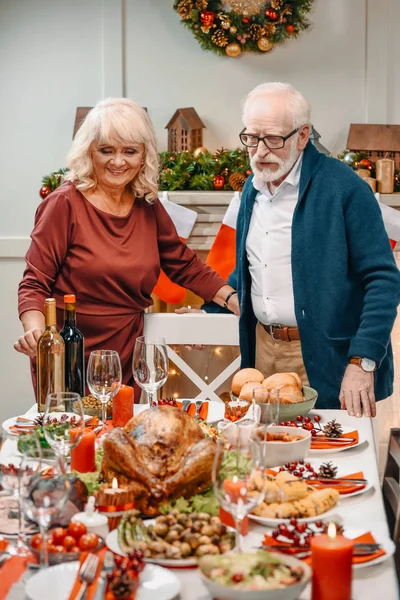 Пожилая пара рядом с рождественским столом — стоковое фото