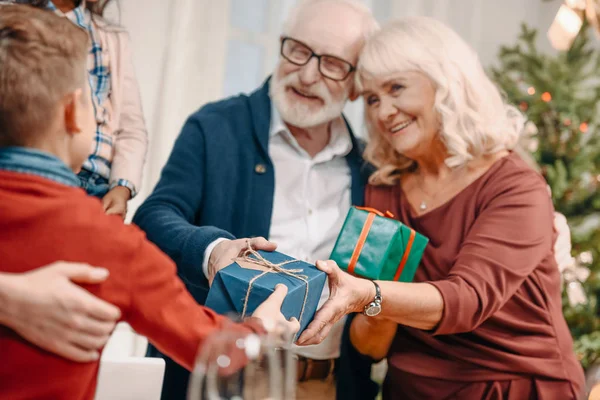 Grandparents presenting gifts to grandson — Stock Photo, Image