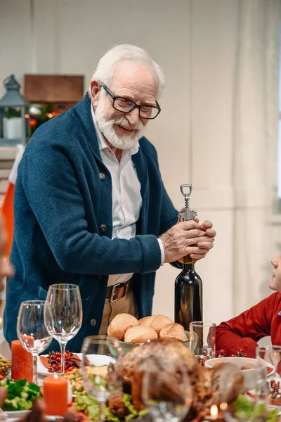 Hombre mayor abriendo botella de vino — Foto de Stock