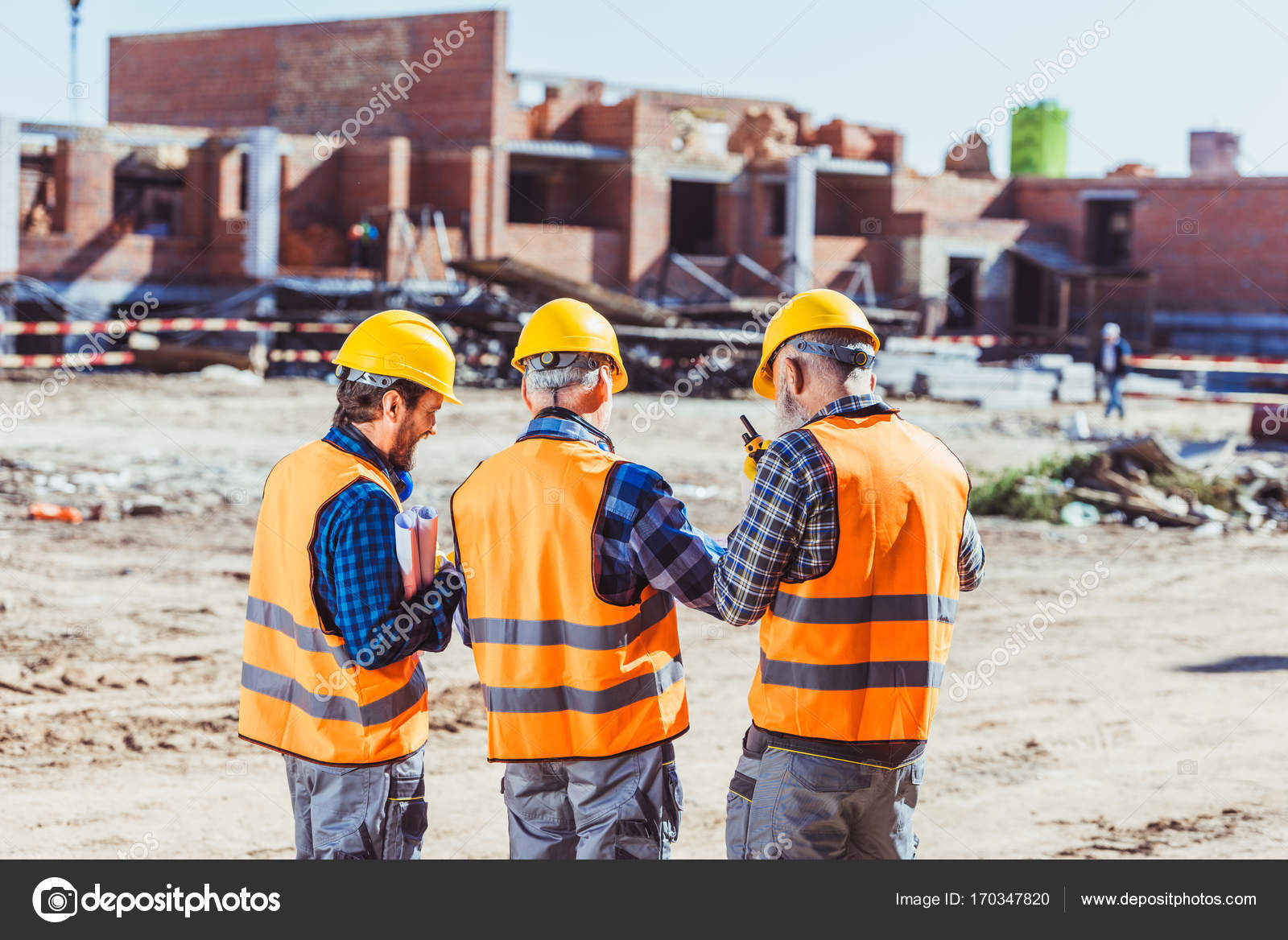 Three workers at construction site Stock Photo by ©ArturVerkhovetskiy