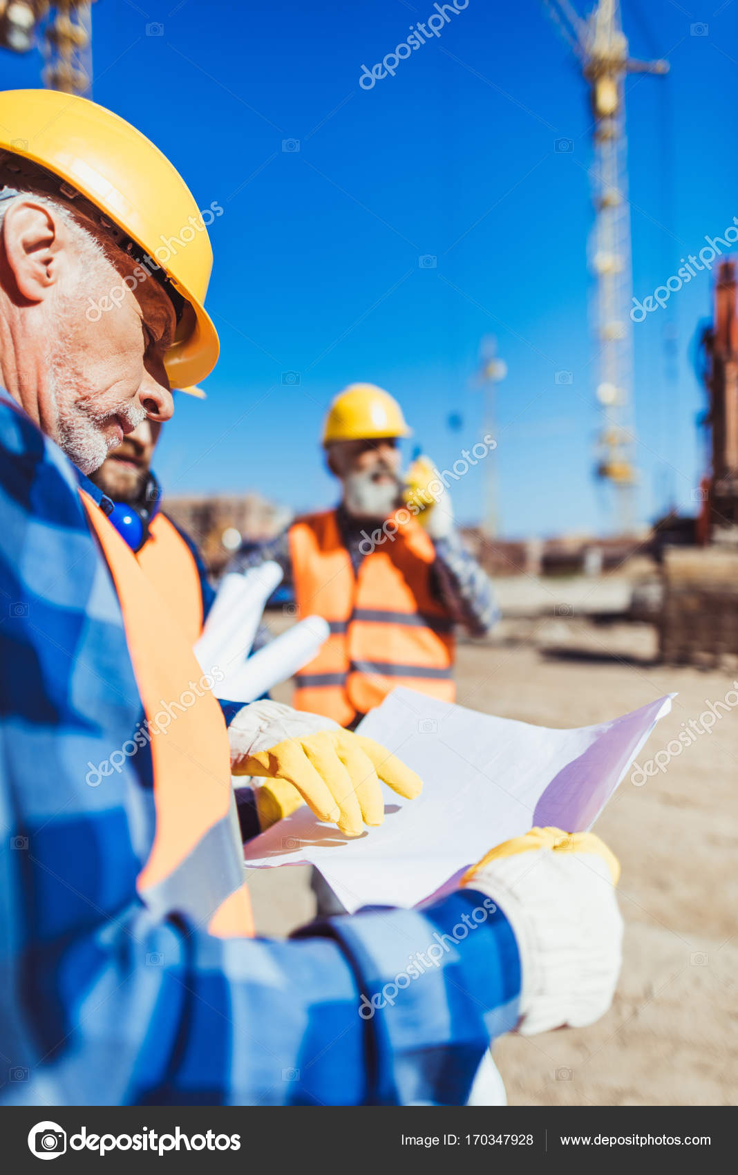 Construction Worker Examining Building Plan Stock Photo construction-worker-examining-building-plan-stock-photo