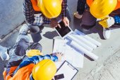 Építőipari munkások, épület tervek megvitatása