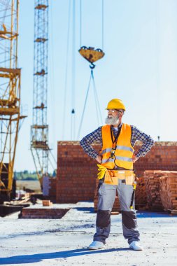 worker in uniform standing at construction site clipart