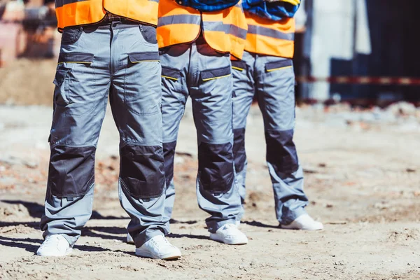 Three builders at construction site — Stock Photo, Image