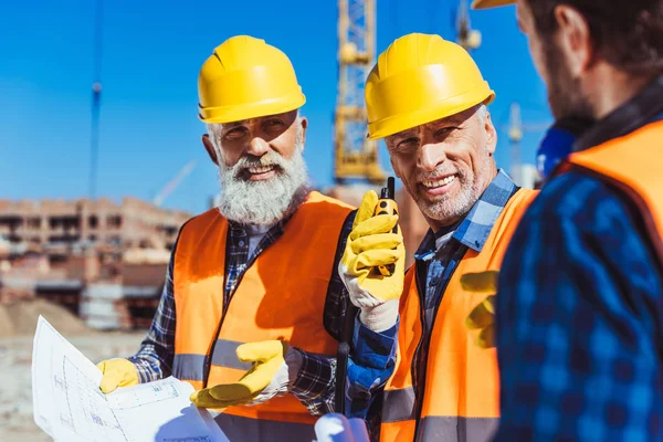 Trabajadores de la construcción discutiendo planes de construcción — Foto de Stock