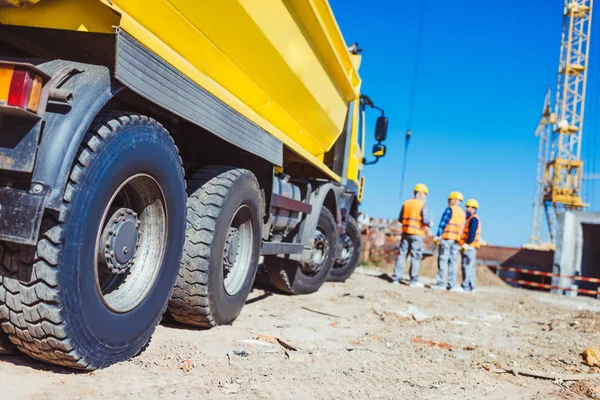 Camiones de punta y trabajadores de la construcción — Foto de Stock