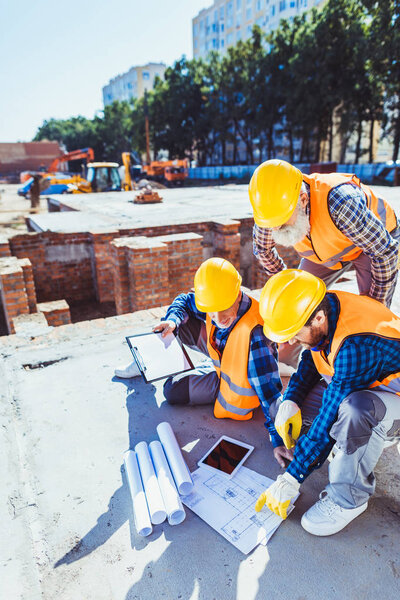 construction workers examining building plans