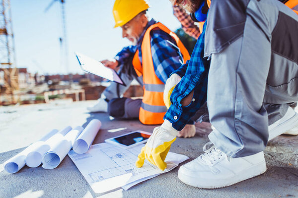 construction workers examining building plans