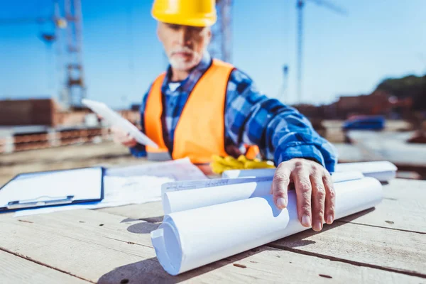 Trabalhador da construção civil com planos de construção — Fotografia de Stock