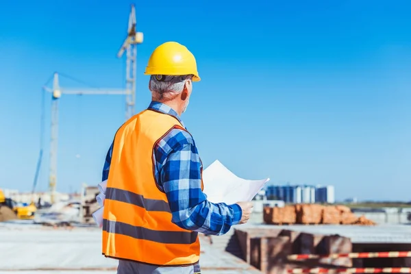 Construction worker holding building plans — Stock Photo, Image