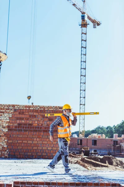 Construction worker holding spirit level — Stock Photo, Image