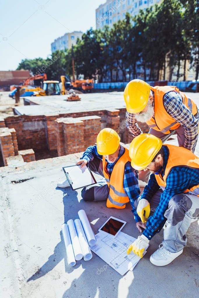 construction workers examining building plans