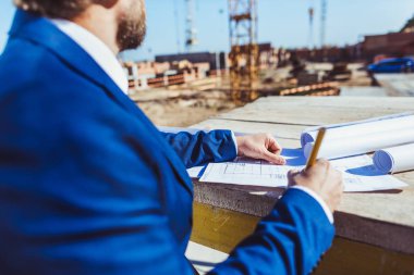 Businessman taking notes at construction site clipart