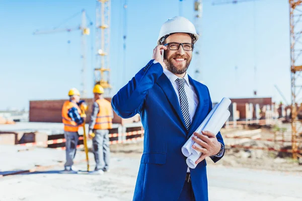 Üzletember beszél telefonon építkezésen — Stock Fotó