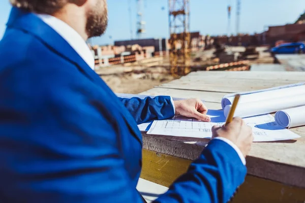 Businessman taking notes at construction site — Stock Photo, Image