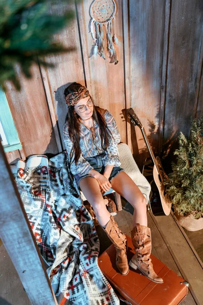 Woman sitting on bench in wooden house — Stock Photo, Image