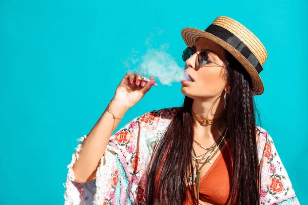 Девушка курит сигареты и выдыхает дым — стоковое фото