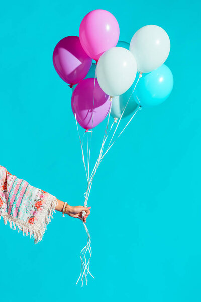 Женщина-хиппи держит цветные воздушные шары
