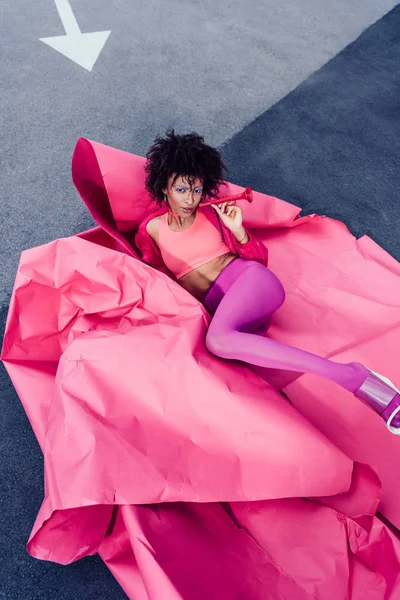 Afro girl posing in pink paper — Stock Photo, Image