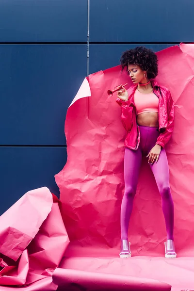 Modelo na moda posando com papel rosa — Fotografia de Stock
