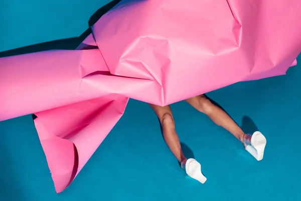 Modelo acostado debajo de papel rosa — Foto de Stock