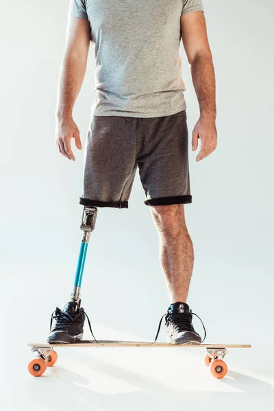 Hombre con prótesis de pierna de pie en el monopatín —  Fotos de Stock