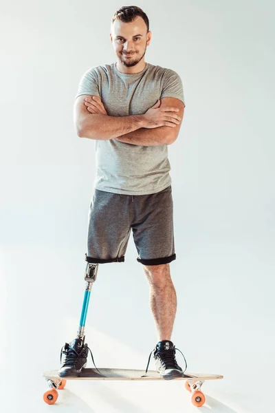 Man with leg prosthesis standing on skateboard