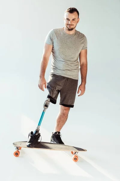 Человек с протезом ноги стоит на скейтборде — стоковое фото