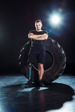 paralympic sportsman leaning on tire clipart