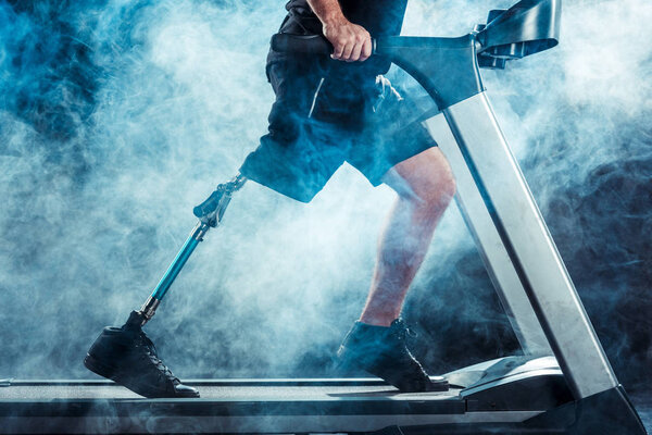 sportsman with leg prosthesis training on treadmill