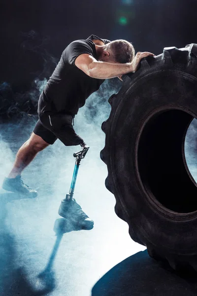 Paralympic sportsman pulling tire — Stock Photo, Image