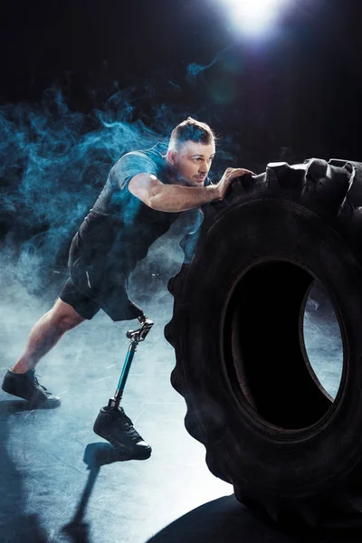 Paralympic sportsman pulling tire — Stock Photo, Image