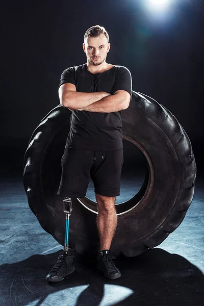 Sportif paralympique appuyé sur un pneu — Photo