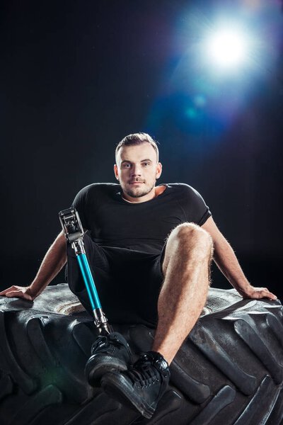 paralympic sportsman resting on tire