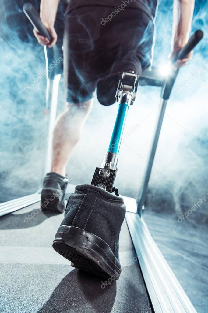 sportsman with leg prosthesis training on treadmill