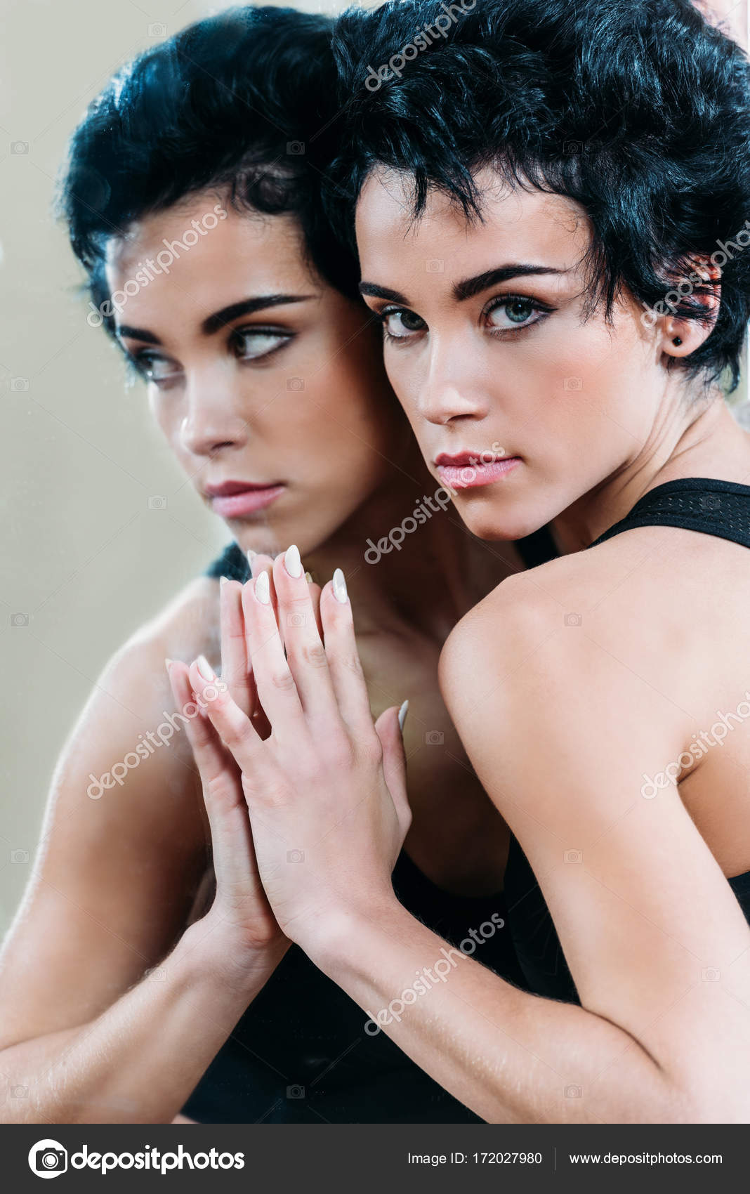 Woman touching reflection in mirror — Stock Photo © ArturVerkhovetskiy