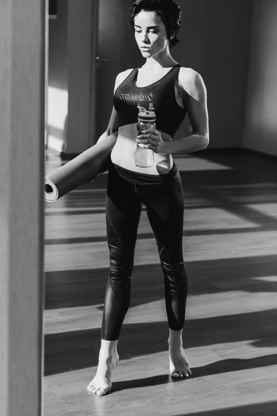 Woman with yoga mat and water — Stock Photo, Image