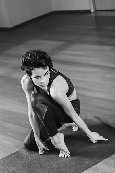 Mujer sentada en esterilla de yoga — Foto de Stock