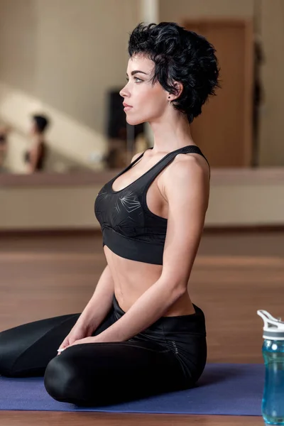 Женщина расслабляется на коврик йоги — стоковое фото