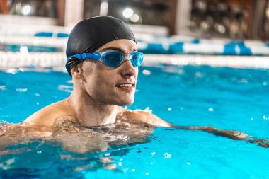 sportsman in goggles swimming in pool