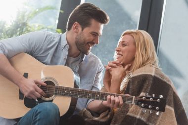 Kız arkadaşı için gitar çalan adam.