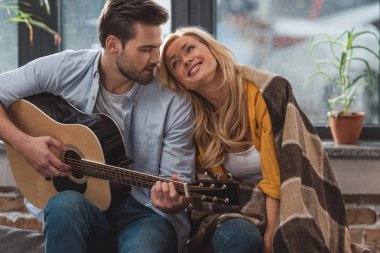 Kız arkadaşı için gitar çalan adam.