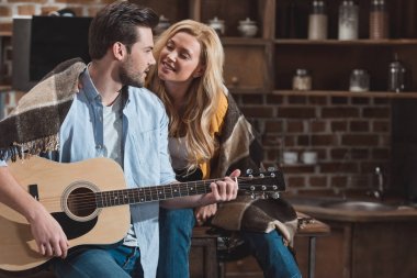 Kız arkadaşı için gitar çalan adam.