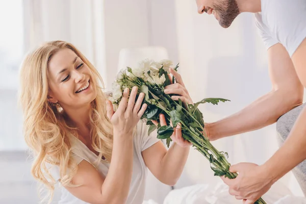 Man presenterar blommor för flickvän — Stockfoto