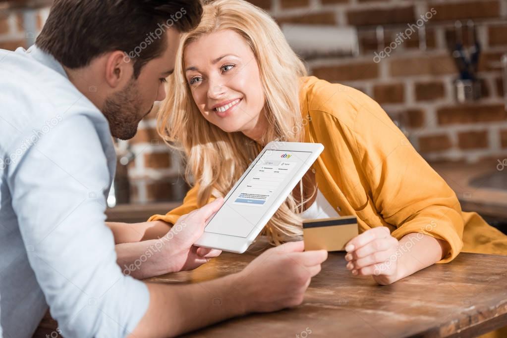 Happy beautiful couple making e-shopping with tablet